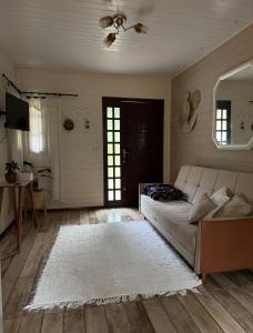 a living room with a couch and a mirror at Cabanas na Serra - Celeste, natureza & privacidade in São Francisco de Paula