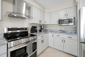 a kitchen with white cabinets and black appliances at Manatee By The Bay in Crystal River