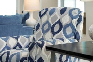a living room with a blue and white chair and a table at Manatee By The Bay in Crystal River