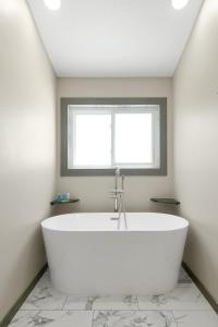 a white bath tub in a bathroom with a window at Manatee By The Bay in Crystal River +62 photos