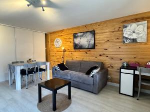 una sala de estar con un sofá y una mesa en T2 ensoleillé. Terrasse, jardin commun, vue, parking., en Cauterets 14 fotos más