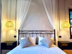 una camera con un letto bianco con due cuscini di APPARTAMENTO Casale Le Civette a Montepulciano