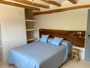 a bedroom with a bed with blue pillows at El Masico Rural in Olba