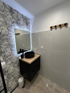 a bathroom with a sink and a mirror at Obuncoeur avec spa in Le Gosier +7 photos
