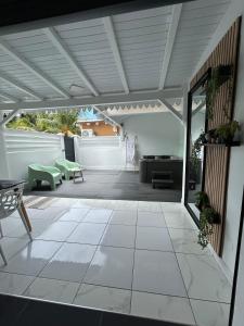 an open patio with a table and chairs on a patio at Obuncoeur avec spa in Le Gosier
