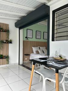 a bedroom with a bed and a table with chairs at Obuncoeur avec spa in Le Gosier