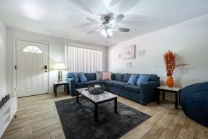 a living room with a blue couch and a ceiling fan at The Family Friendly Funhouse in Phoenix