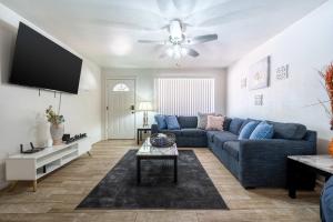 a living room with a blue couch and a tv at The Family Friendly Funhouse in Phoenix