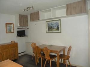 een eetkamer met een houten tafel en stoelen bij Studio accueillant aux Deux Alpes de 21 m² avec vue montagne in Les Deux Alpes