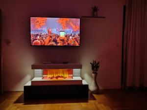 a living room with a tv above a fireplace at My Place in Donje Mladice +14 photos