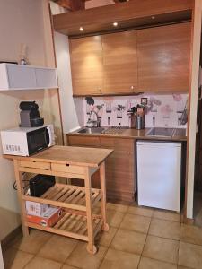a kitchen with a wooden table and a microwave at 316 - Dúplex Pla de L'Ermita Boí Taüll in Pla de l'Ermita +5 photos