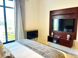 a bedroom with a flat screen tv and a bed at Menlyn Maine Residences in Pretoria