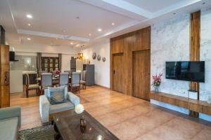 a living room with a television and a dining room at The Medona - A Peaceful Farmstay in Thūr