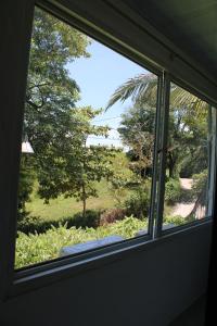 a window view of a garden from a house at Posada Campestre brisas del camino in Puerto Triunfo