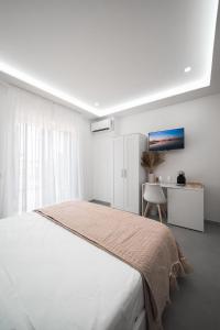 a white bedroom with a bed and a desk at B&B CaMa in Gragnano