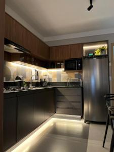 eine Küche mit Edelstahlkühlschrank und Schränken in der Unterkunft Flat ESPETACULAR PRAIA DE CAMBURI Long Stay in Vitória