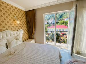 a bedroom with a bed and a large window at My White Residence in Trabzon