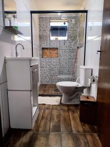 a small bathroom with a toilet and a shower at Chácara com piscina área de lazer completa estilo rústico em Socorro in Socorro
