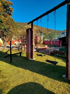 an empty playground with swings in a park at Chácara com piscina área de lazer completa estilo rústico em Socorro in Socorro