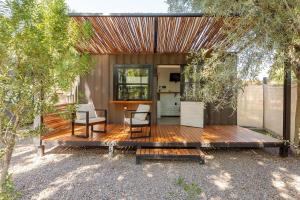 Las CompuertasTiny House Las Compuertas的房屋设有木甲板,配有桌椅