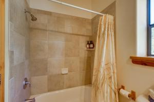 a bathroom with a tub and a shower curtain at Mtn-View Deck: Cabin Getaway in Angel Fire in Angel Fire +21 photos