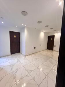 een lege kamer met 2 deuren en een marmeren vloer bij Sphinx middle east pyramids in Banī Ghālib