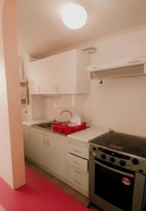 a kitchen with white cabinets and a red sink at Departamento Gran vista de ciudad copiapó mínimo 3 noches in Copiapó