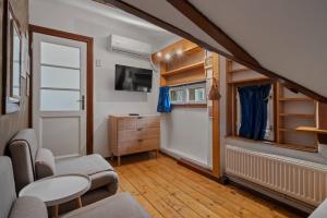 a small living room with a table and a tv at Interbelic Villa near Old Town in Bucharest