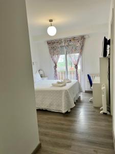 a bedroom with a bed and a window at El Marquesado de Santiago en Milladoiro in Amés