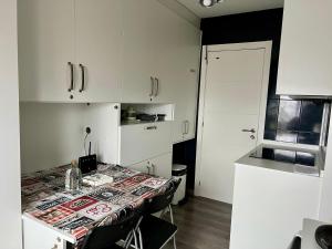 a kitchen with a table with chairs and white cabinets at El Marquesado de Santiago en Milladoiro in Milladoiro