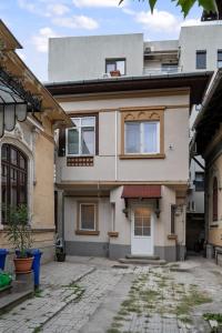 a house with a courtyard in front of it at Interbelic Villa near Old Town in Bucharest