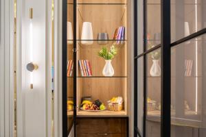a book shelf with a plate of fruit and vases at Nest One Luxe, Элитные апартаменты с террасой и панорамным видом in Tashkent