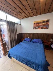 a bedroom with a blue bed with a wooden ceiling at Hostal Boutique Reina del Mar in Cartagena