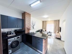 a kitchen with a washer and dryer and a living room at Executive Apartment at Waterfall Ridge in Midrand +59 photos