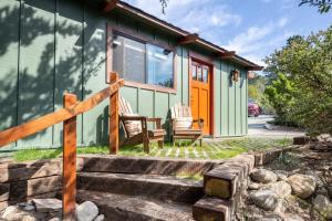 a green cottage with two chairs on the stairs at The Love Shack in Carmel