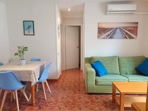 a living room with a green couch and a table at 1ª LÍNEA DAYTONA BEACHFRONT in Oropesa del Mar