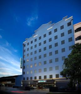 a large white hotel building with a blue sky at Hotel 81 Premier Hollywood in Singapore