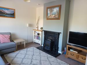 a living room with a fireplace and a television at Bungalow in Baltinglass in Baltinglass