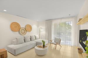 un salon blanc avec un canapé et une table dans l'établissement Serenidad del Pacifico Condo, Resort Pools & Near Coco Beach, à Coco