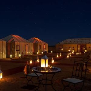 a group of tents in a desert at night at Sahara Soul luxury Camp in Merzouga +55 photos
