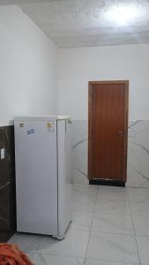 a white refrigerator and a wooden door in a room at Espaço familiar 2 in Vila Velha +2 photos