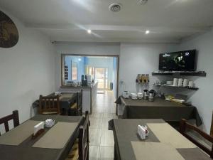 a dining room with tables and a television on the wall at Hostel Danny in El Calafate