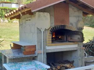 a outdoor pizza oven with a fire in it at Pass Assaggiando in Rubiana