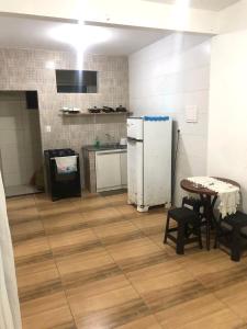 a kitchen with a refrigerator and a table and chairs at Sua Casa em MSP in Morro de São Paulo