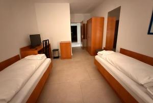 a room with two beds and a television in it at Hotel G&K in Giesen +6 photos