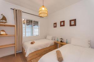 ウィルダネスにあるDe Schuit Beach Houseのベッド2台と窓のある寝室
