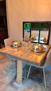 a wooden table with glasses and plates on it at ETOILE & SENS du Quercy in Limogne-en-Quercy