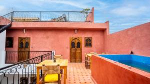 a house with a balcony with a swimming pool at Riad L'EncensOriental in Marrakech