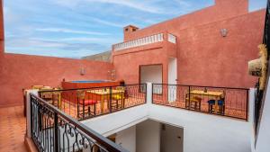 a balcony with chairs and tables on a building at Riad L'EncensOriental in Marrakech