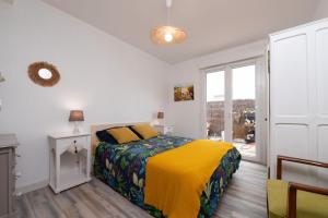 a bedroom with a bed with a yellow blanket at Maison chaleureuse entre deux mers in Saint-Pierre-Quiberon